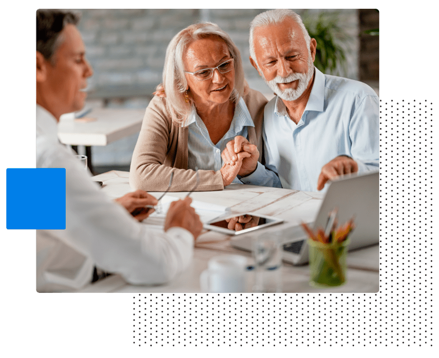 Pareja de personas mayores viendo con ilusión lo que les explica otra persona